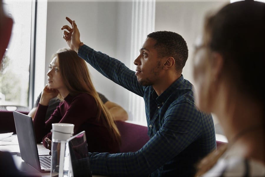 man raising hand to ask a question in velociteach class