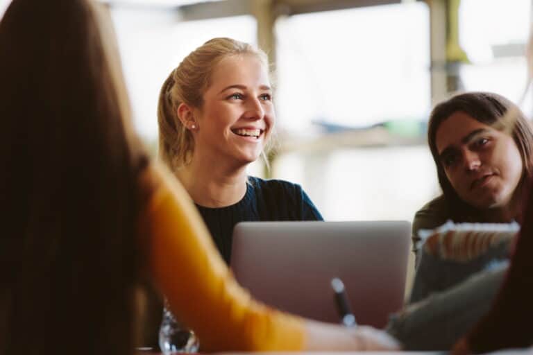 woman sitting at laptop and smiling.