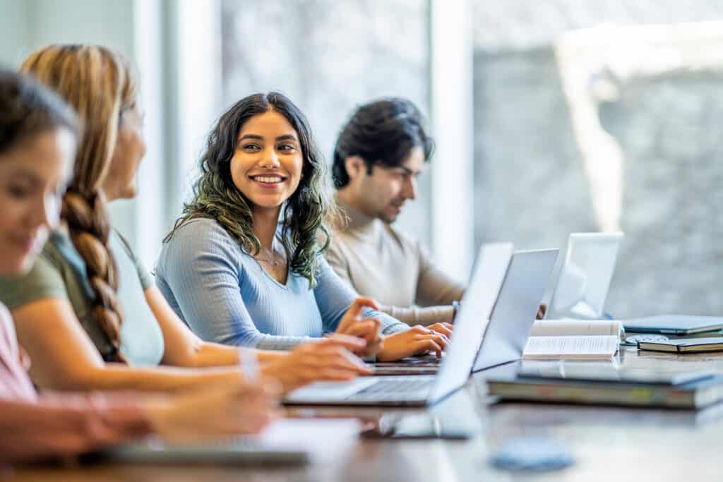 students at table on laptops.