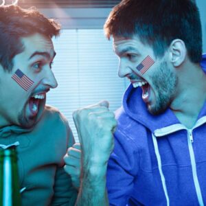 Two young men watching sports competition and drinking beer.