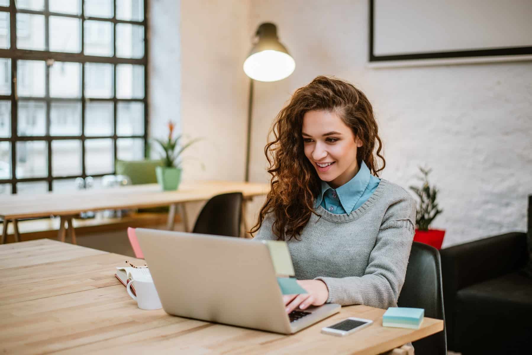 woman smiling while on laptop.