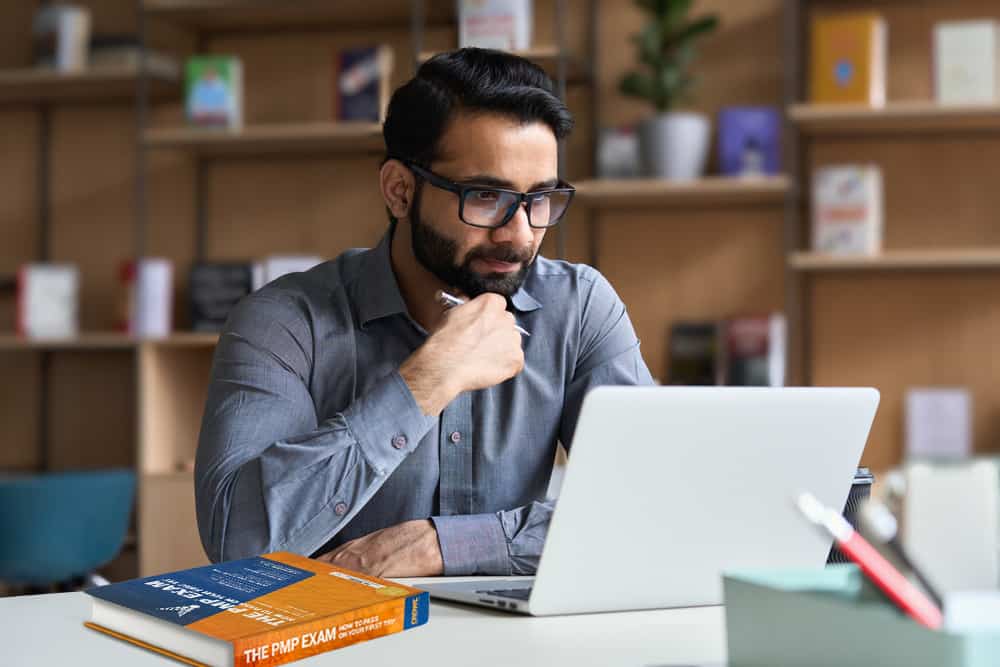 man on laptop doing Velociteach PMP exam prep